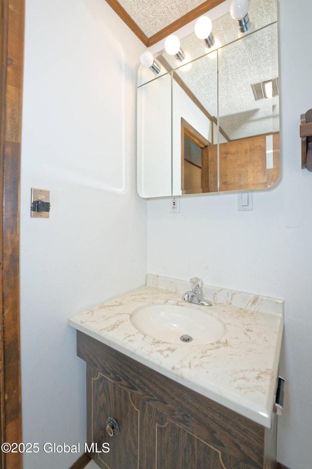 bathroom with visible vents, vanity, and a textured ceiling