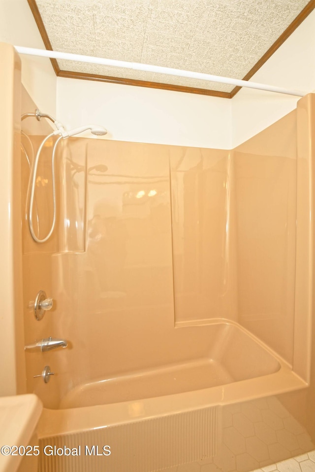 full bathroom with ornamental molding,  shower combination, and a textured ceiling