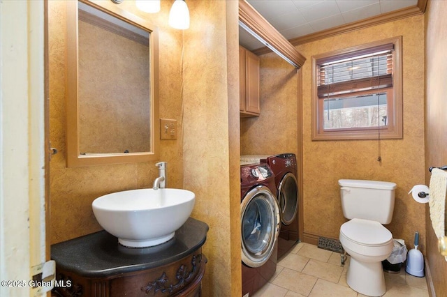 half bathroom with toilet, ornamental molding, tile patterned floors, independent washer and dryer, and vanity