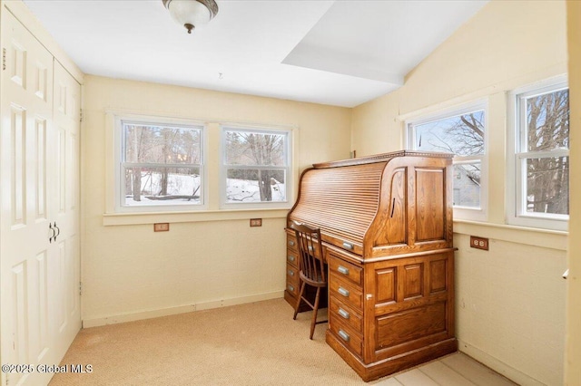 home office with a healthy amount of sunlight, light carpet, and baseboards