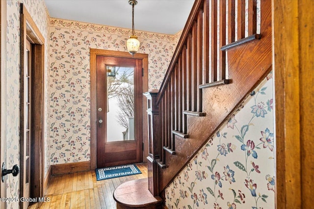 entryway with wallpapered walls, baseboards, and hardwood / wood-style flooring