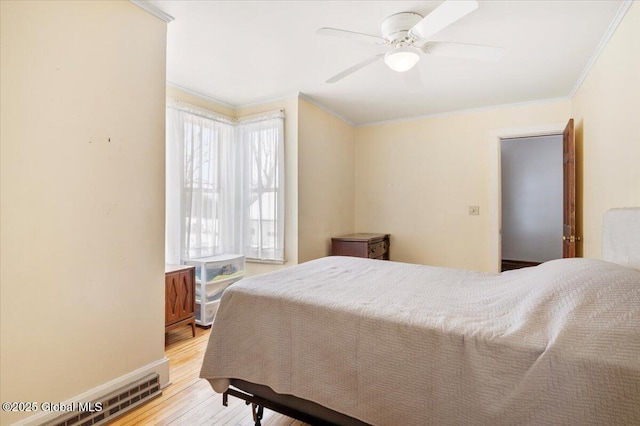 bedroom featuring visible vents, ornamental molding, ceiling fan, wood finished floors, and baseboards