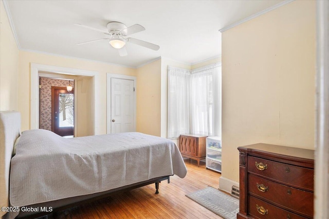 bedroom featuring light wood-style floors, a ceiling fan, and crown molding