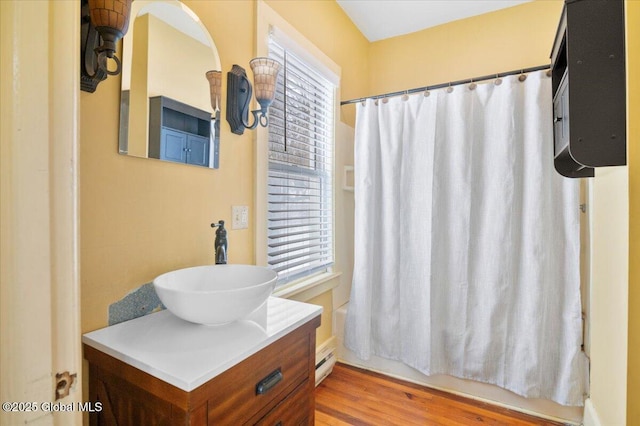 full bathroom with vanity, wood finished floors, a wealth of natural light, and shower / bathtub combination with curtain