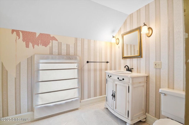 bathroom with vaulted ceiling, vanity, toilet, and wallpapered walls