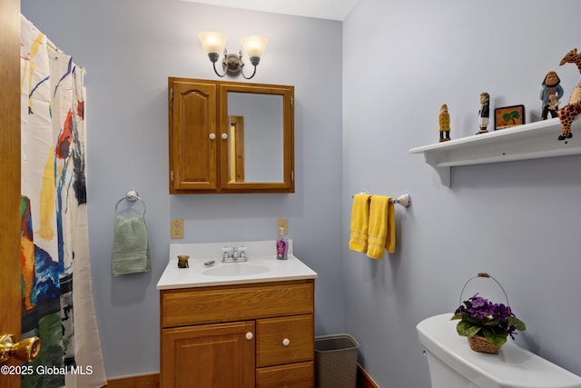 bathroom featuring toilet, a shower with shower curtain, and vanity