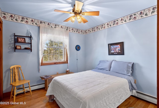 bedroom featuring a baseboard radiator, ceiling fan, and wood finished floors