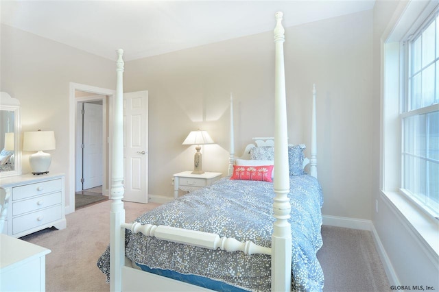 bedroom featuring light carpet and baseboards