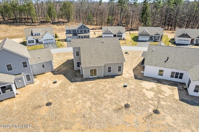 drone / aerial view with a residential view and a wooded view