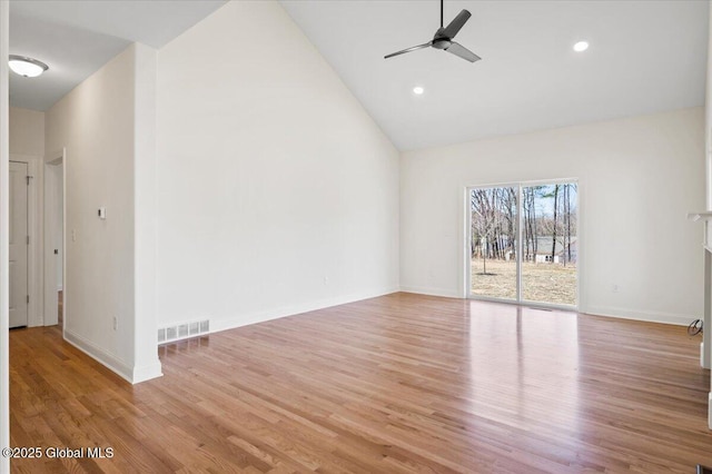 interior space with high vaulted ceiling, baseboards, ceiling fan, visible vents, and wood finished floors