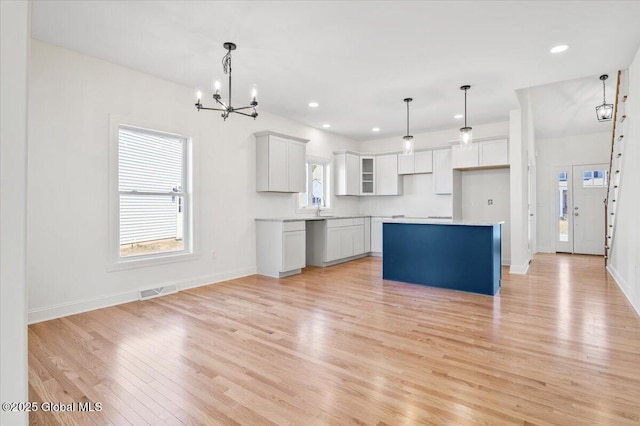 kitchen featuring visible vents, recessed lighting, light wood-style floors, a center island, and a notable chandelier