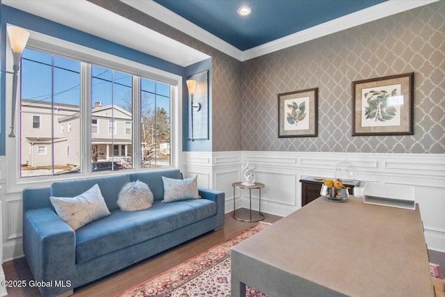 living room with a wainscoted wall, ornamental molding, wallpapered walls, and wood finished floors