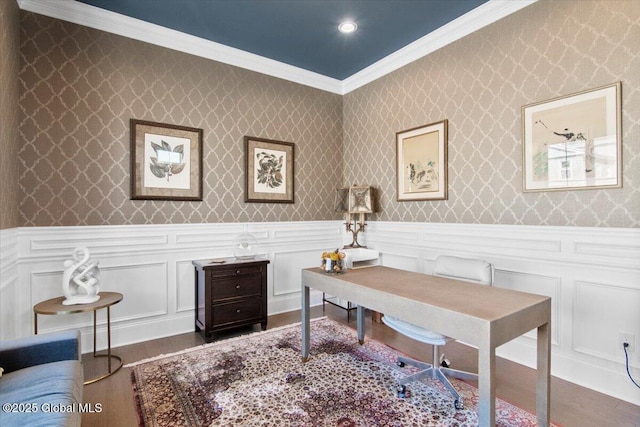 home office featuring wood finished floors, ornamental molding, wainscoting, and wallpapered walls