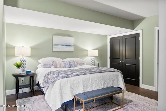 bedroom with a closet, baseboards, and wood finished floors