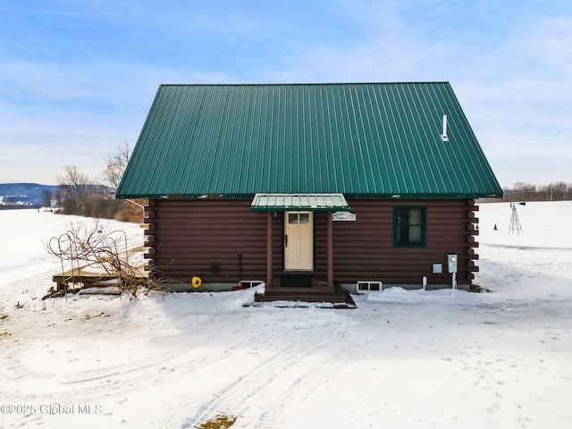 log-style house featuring entry steps, metal roof, and log siding