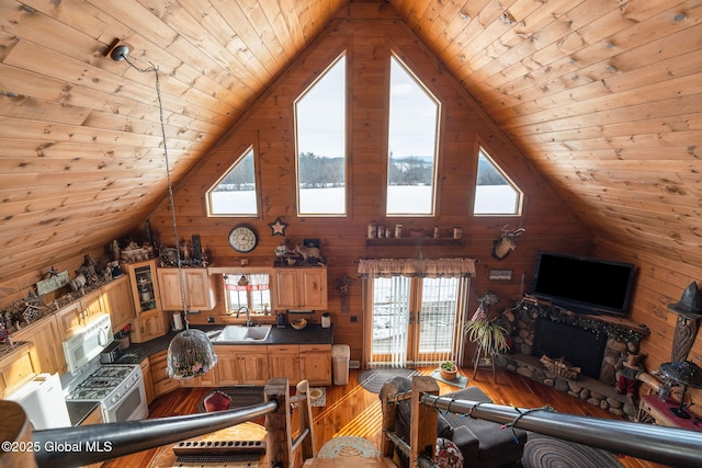 living area with high vaulted ceiling, wood finished floors, wood ceiling, and wooden walls