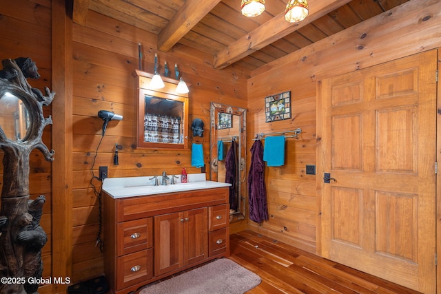 bathroom featuring wooden ceiling, wooden walls, beam ceiling, and vanity