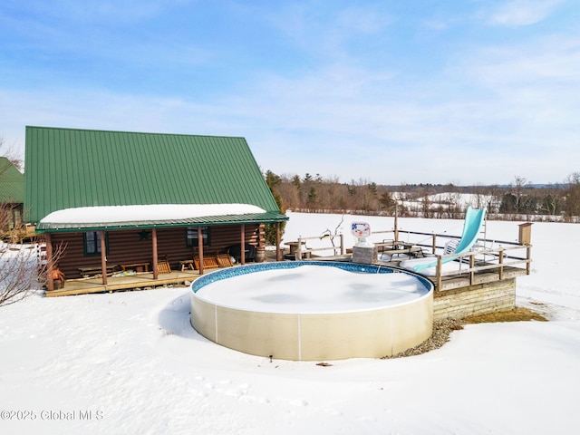 snow covered pool with a water slide and covered porch