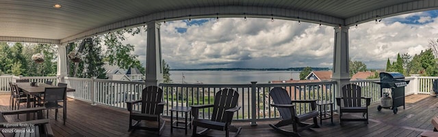 deck featuring a water view and outdoor dining space