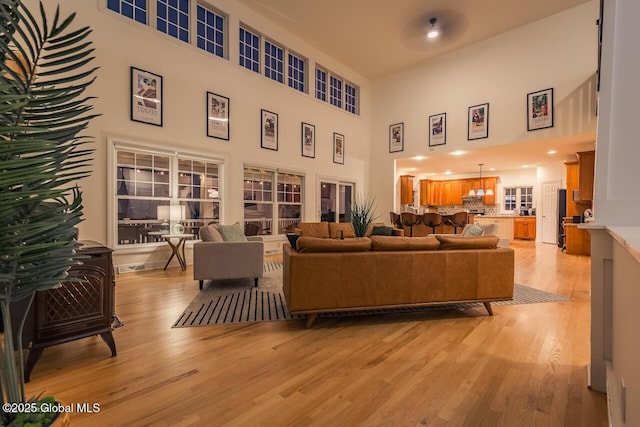 living room with light wood-style floors and a high ceiling