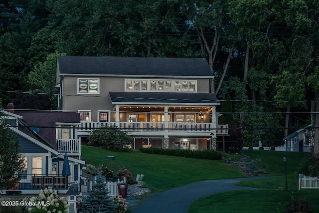 rear view of property featuring a lawn