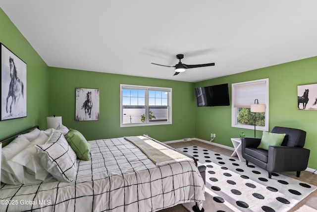 carpeted bedroom with baseboards and a ceiling fan