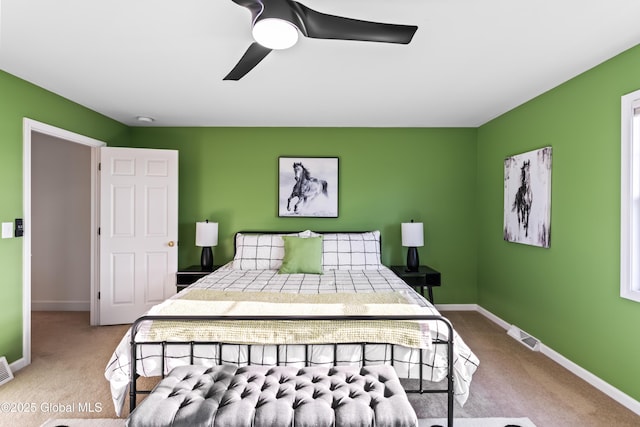 carpeted bedroom with ceiling fan and baseboards