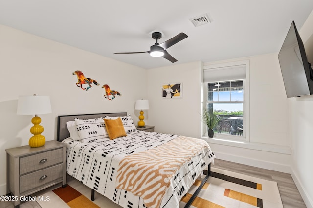 bedroom with visible vents, ceiling fan, light wood-style flooring, and baseboards