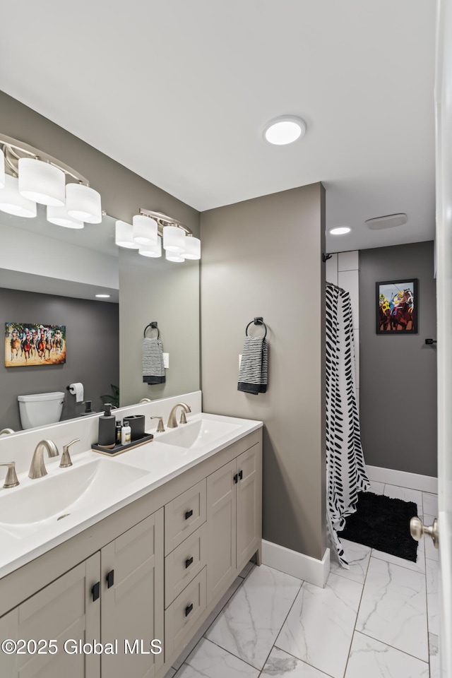 bathroom with marble finish floor, baseboards, a sink, and toilet