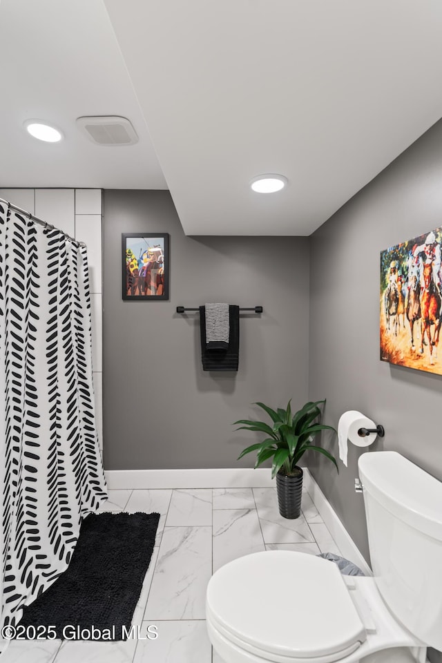 full bathroom featuring marble finish floor, a shower with curtain, toilet, and baseboards