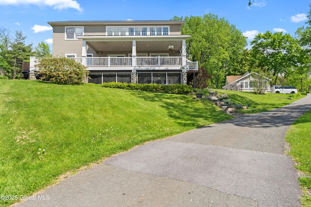 exterior space with a balcony and a front yard