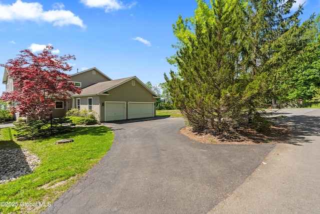 view of front facade with an attached garage, a front lawn, and aphalt driveway