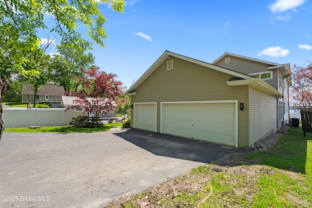 garage with central AC unit and fence