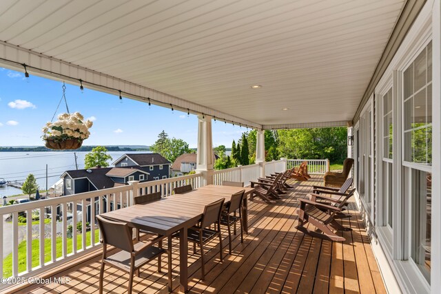 wooden deck featuring outdoor dining area and a water view