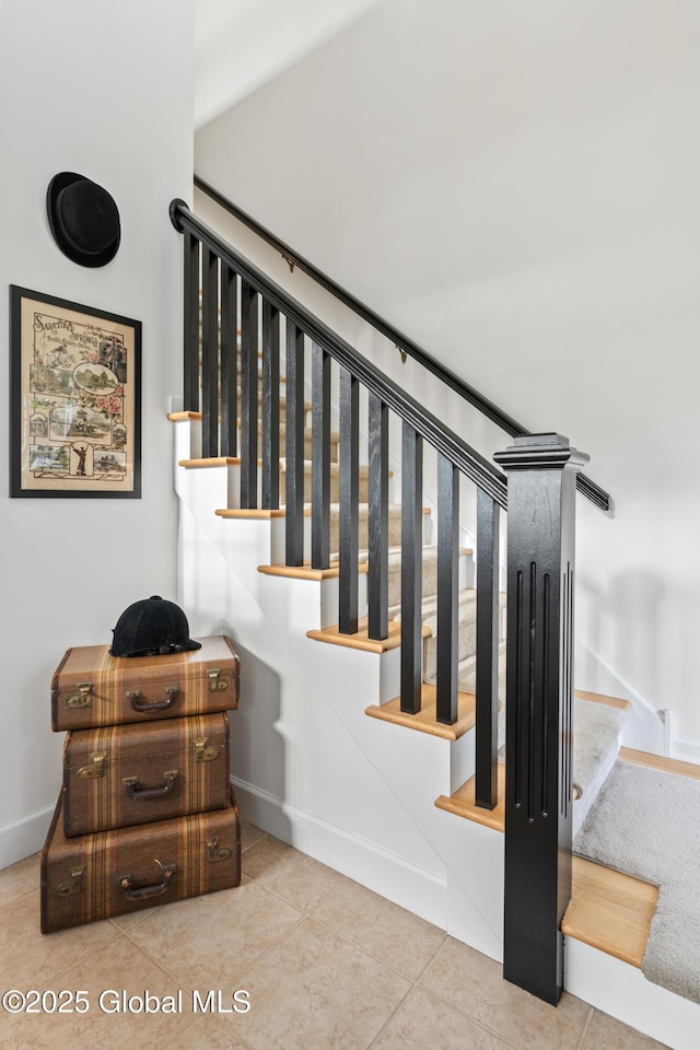 staircase featuring tile patterned flooring and baseboards