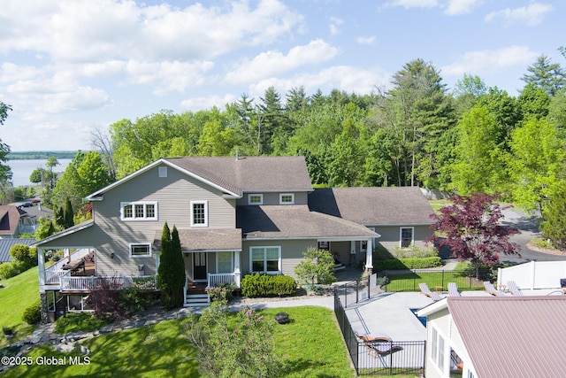 traditional-style home featuring fence, a gate, a fenced in pool, a front lawn, and a patio area