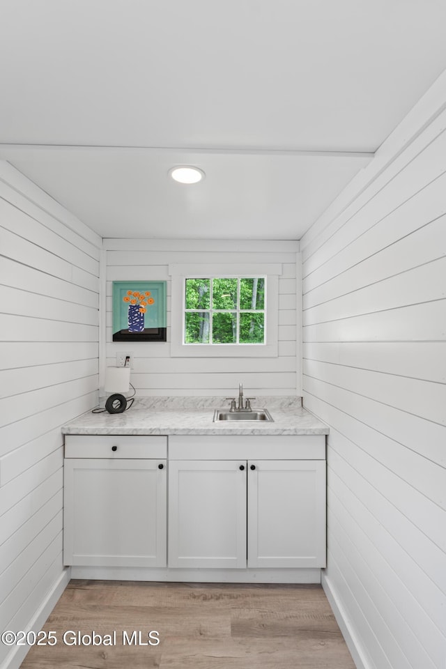 bathroom with wood finished floors, vanity, and wooden walls