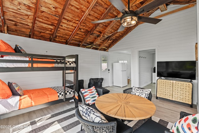 bedroom featuring vaulted ceiling with beams, wooden walls, wood finished floors, wood ceiling, and freestanding refrigerator