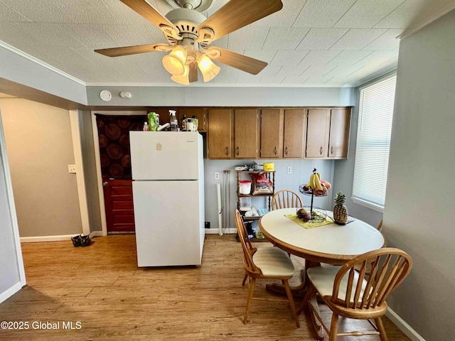 kitchen with freestanding refrigerator, ceiling fan, light wood-style flooring, and baseboards