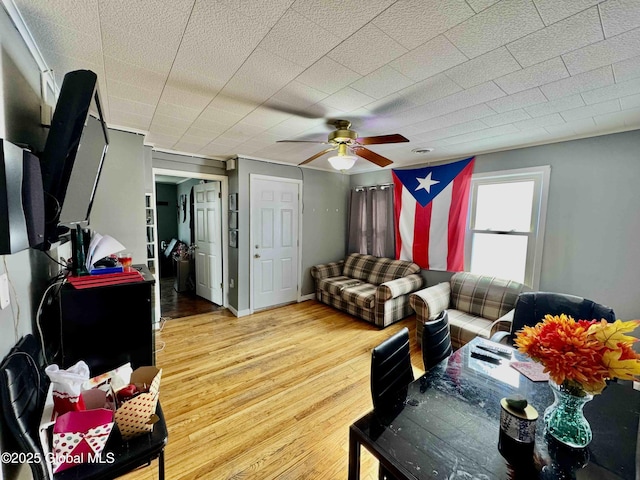 living area with ceiling fan, light wood-style flooring, and baseboards