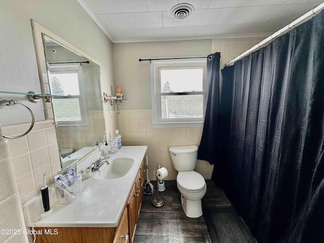 full bathroom featuring toilet, tile walls, visible vents, and a healthy amount of sunlight