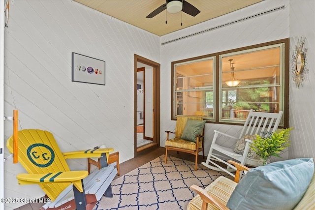 living area with wood finished floors and a ceiling fan