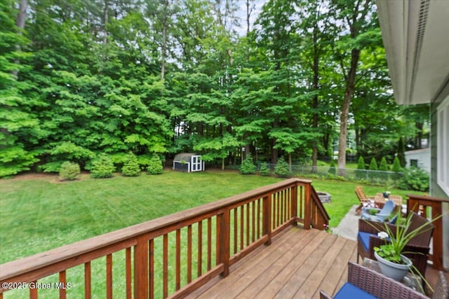 deck with a yard, a shed, an outdoor structure, and a fenced backyard