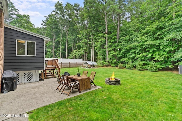 view of yard featuring a patio area, fence, and a fire pit