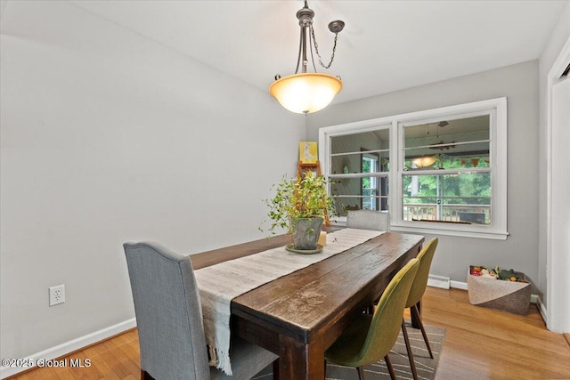 dining area featuring baseboards and light wood finished floors