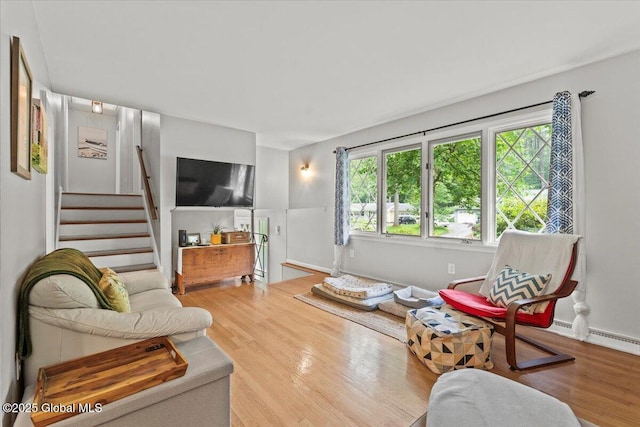 living room with stairs, wood finished floors, and baseboards