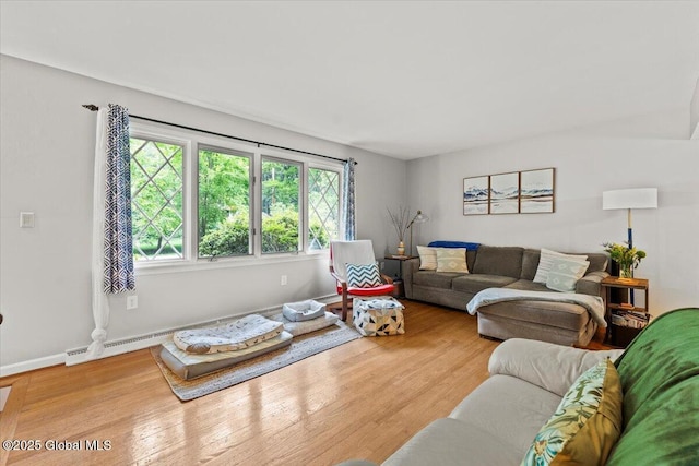 living area with a baseboard radiator, wood finished floors, and baseboards