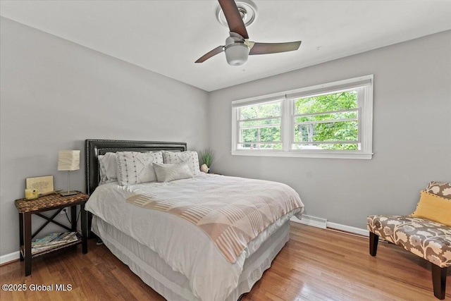 bedroom featuring ceiling fan, baseboards, and wood finished floors