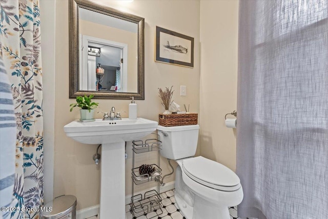 bathroom with baseboards and toilet