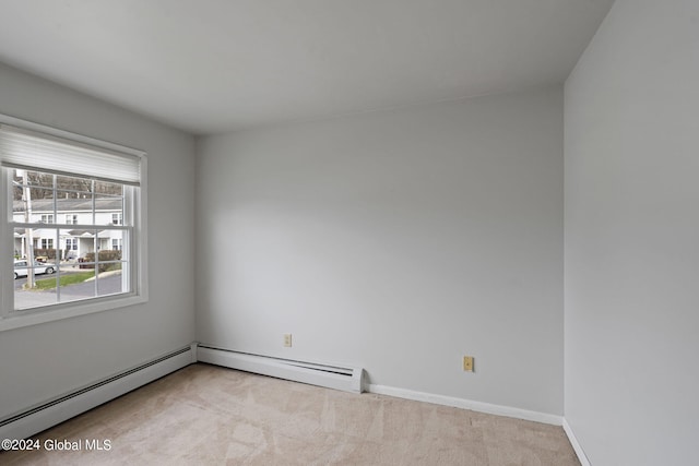 carpeted empty room with a baseboard radiator and baseboards